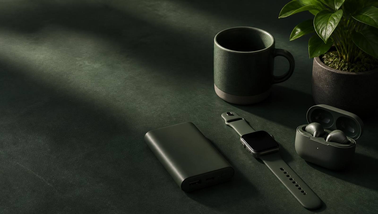 Gadgets and lifestyle accessories arranged on a green backdrop